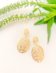 Remy Wicker Gold Oval Link Earrings displayed with green and white florals_m donohue collection