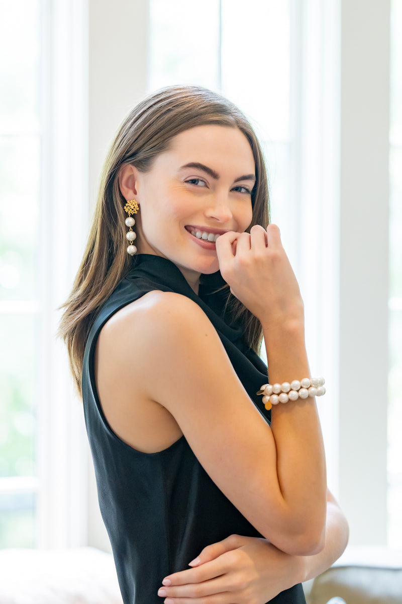 model wearing Jardin gold hydrangea post earrings with triple cotton pearl drops_M Donohue Collection